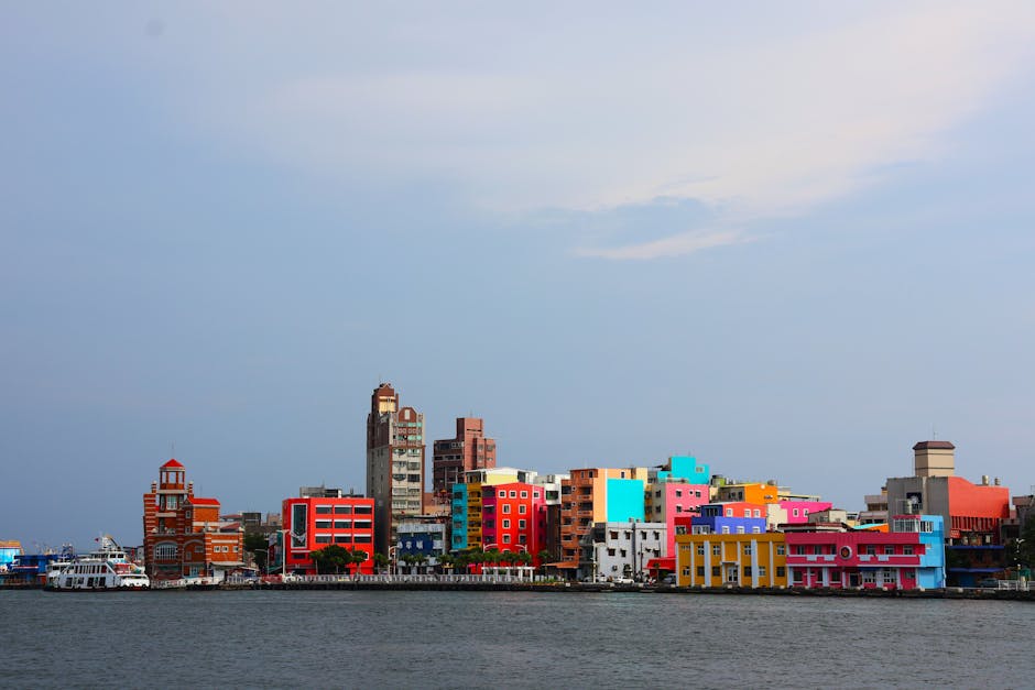 A vibrant view of colorful waterfront buildings in Taiwan, showcasing diverse architecture under a clear sky.