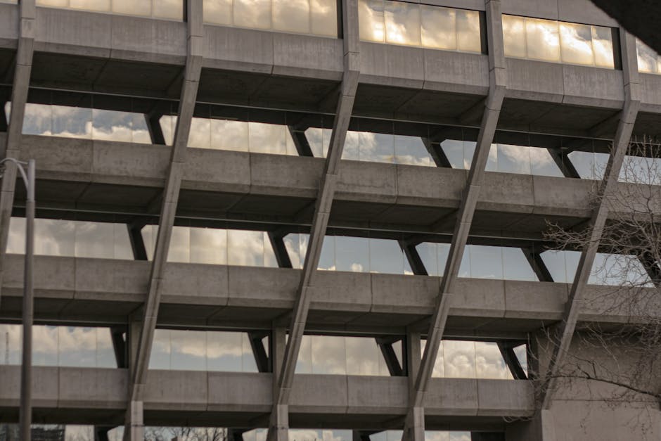 Concrete geometric facade of a Brutalist building in Geelong, reflecting clouds in its windows