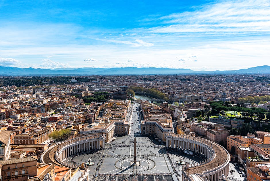 A stunning aerial view of St. Peter's Square in Vatican City with clear blue skies.